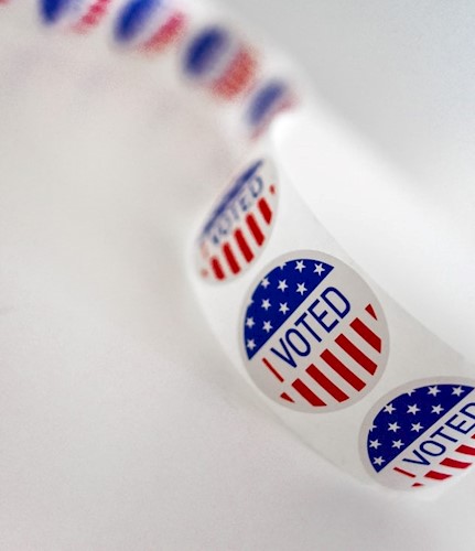 A roll of I vote stickers on a white background